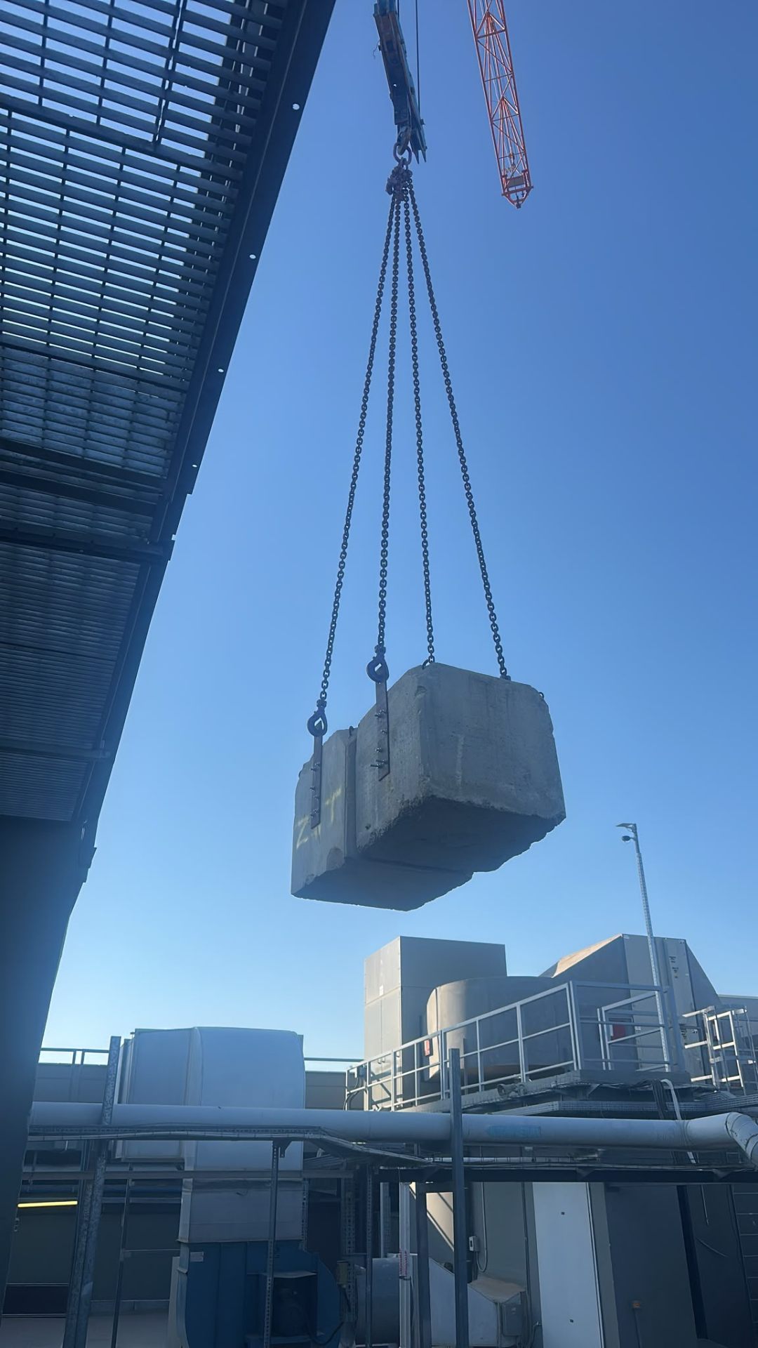 הרמת בלוקי בטון בשרשראות מנוף מעל גג טכני