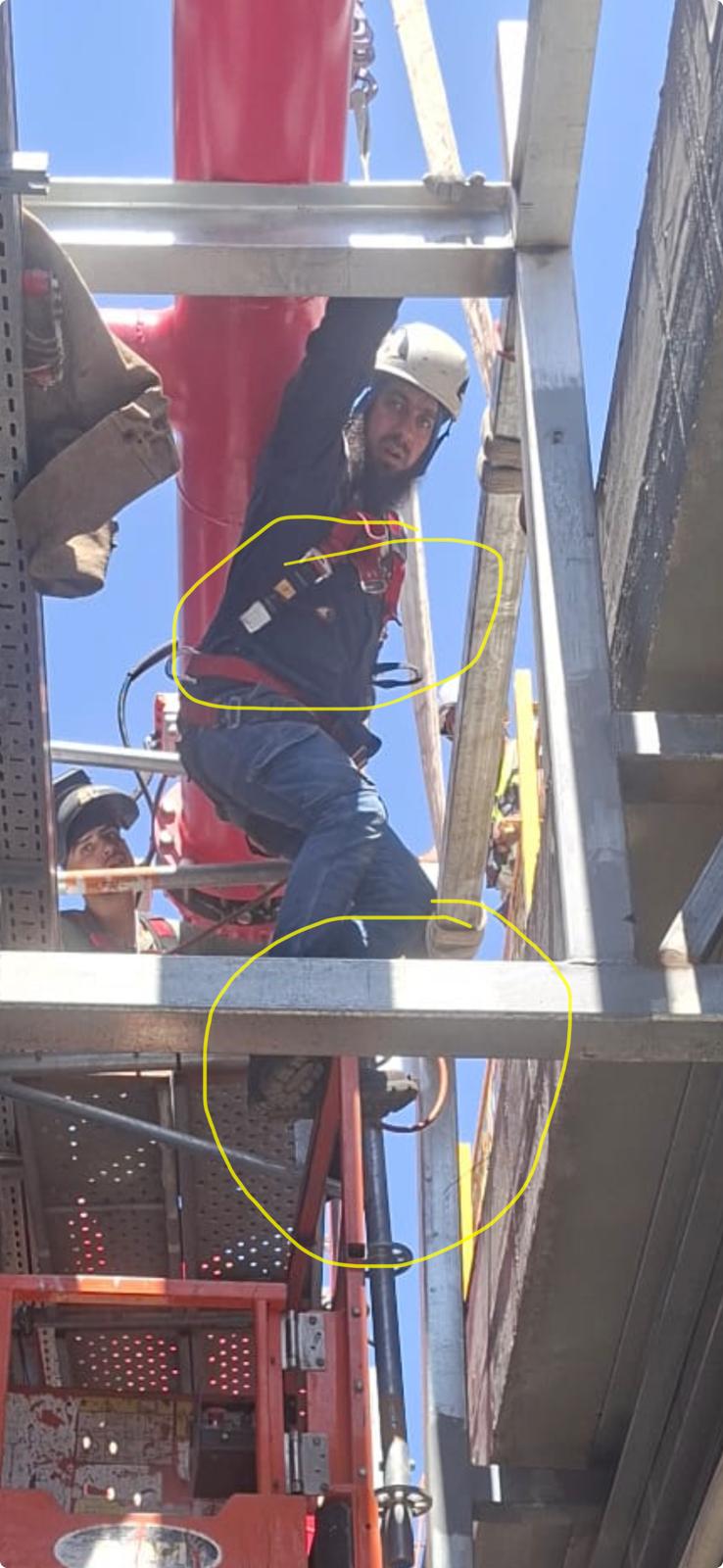 ממצא בטיחות מסומן בעיגול: עיגון רתמה ועמידה על מעקה במקום במה