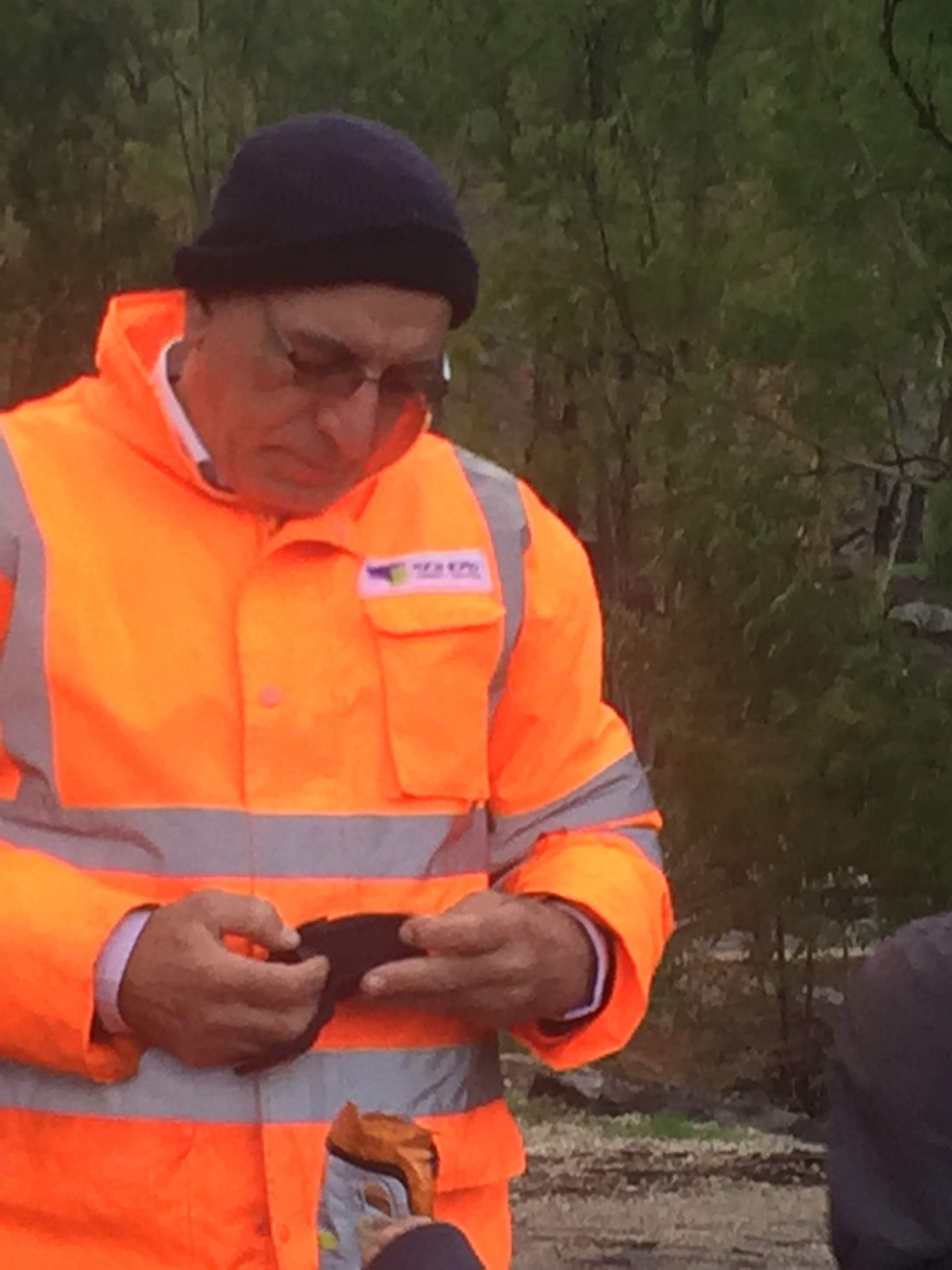 פיקוח בטיחות בשטח במעיל זוהר כתום בתנאי שטח פתוח